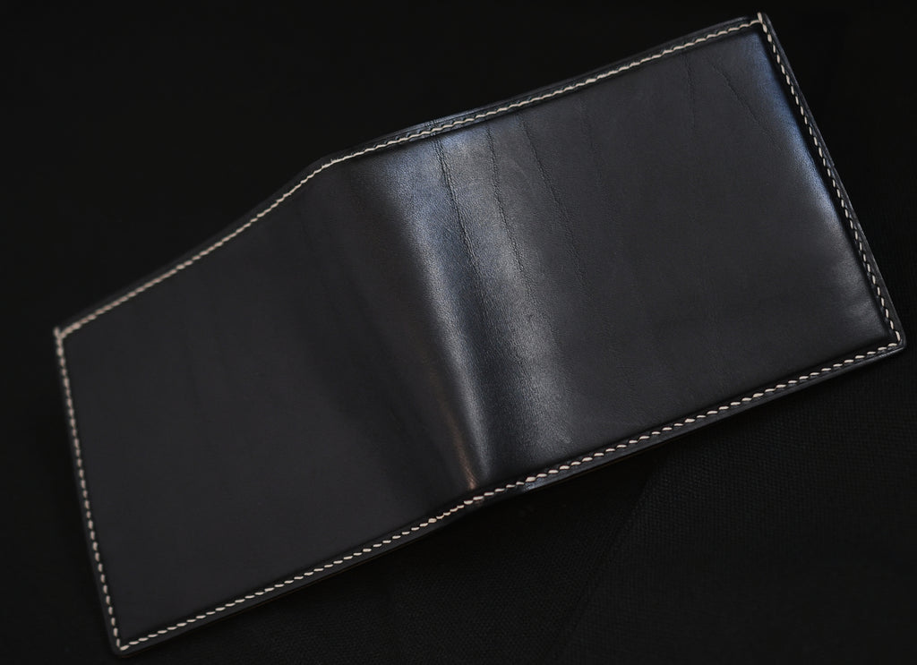 Outside of opened handmade bifold wallet in aged Vachetta leather with natural patina wrinkles and white linen thread hand-stitching — Jackson Boite