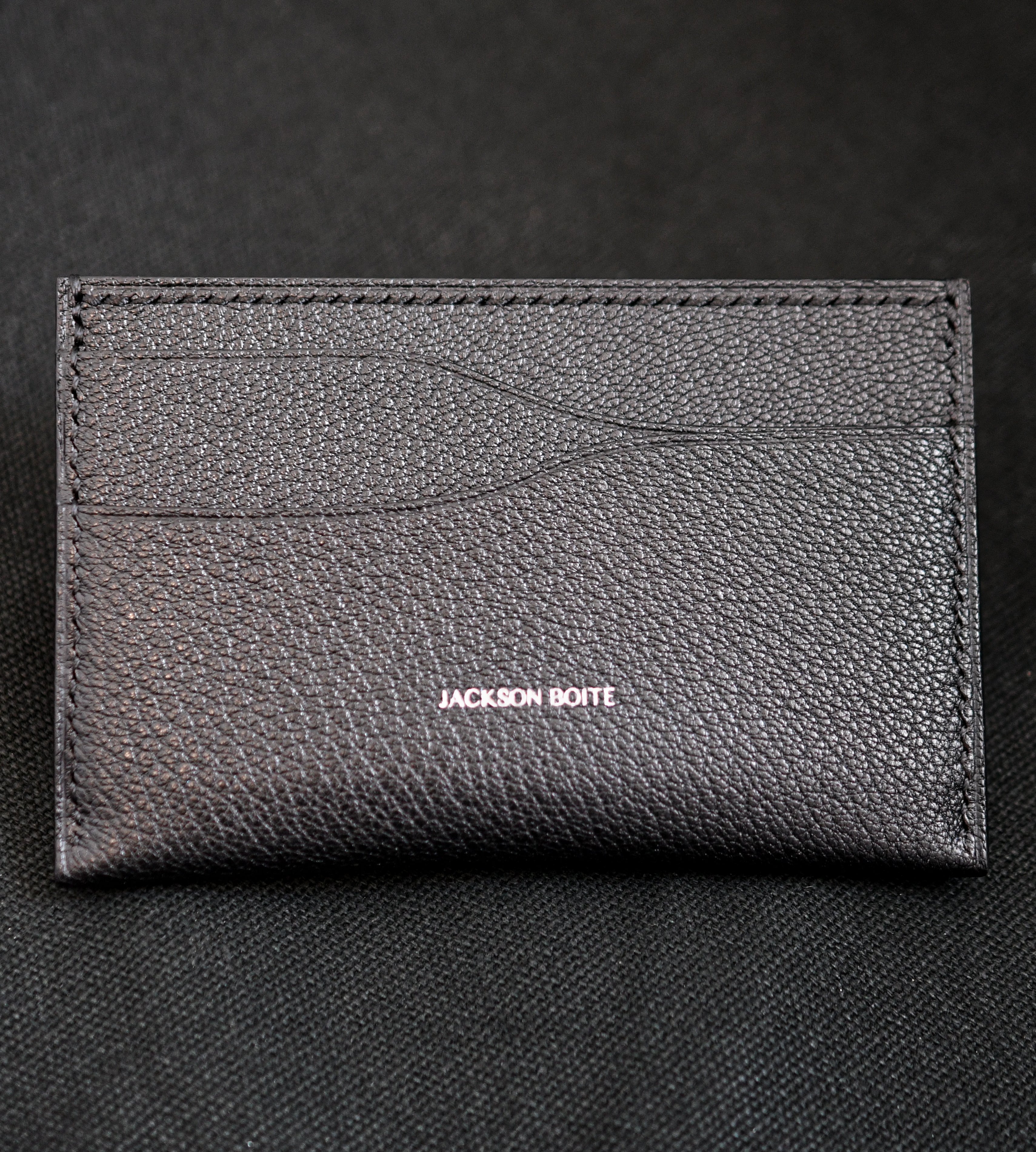 Handmade leather card holder in Alran Sully Noir showing curved card pockets, heat-creased edges and black saddle stitching — Jackson Boite