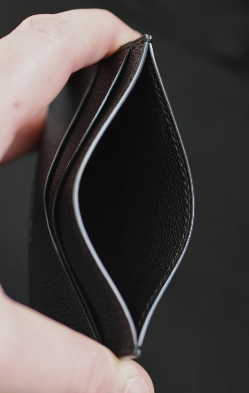 Opened handmade leather card holder made in Alran Sully Noir showing interior pockets, shiny painted edges and black saddle stitching — Jackson Boite