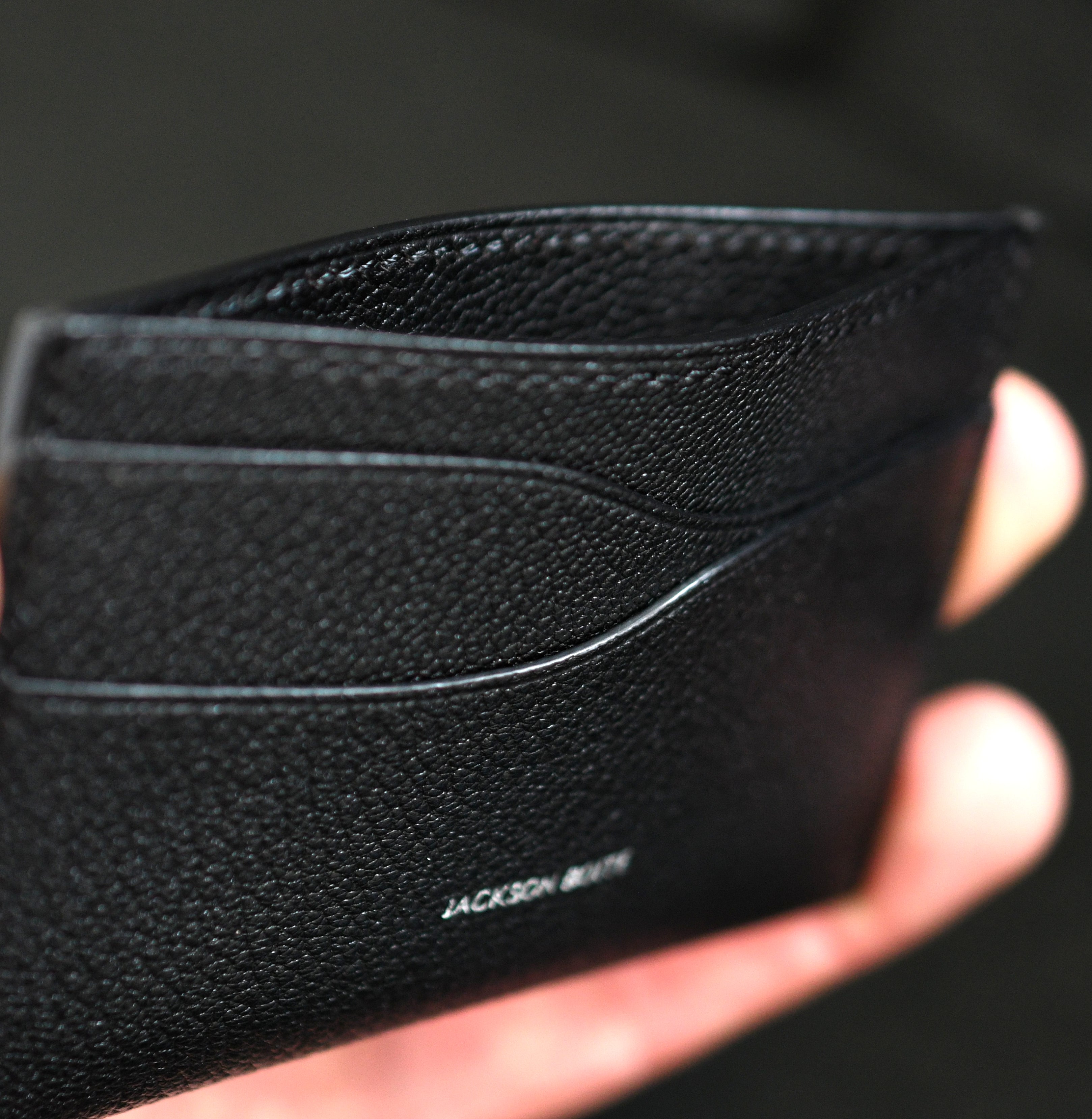 Handmade leather card holder in Alran Sully Noir showing leather details, heat-creased and painted edges with black saddle stitching — Jackson Boite