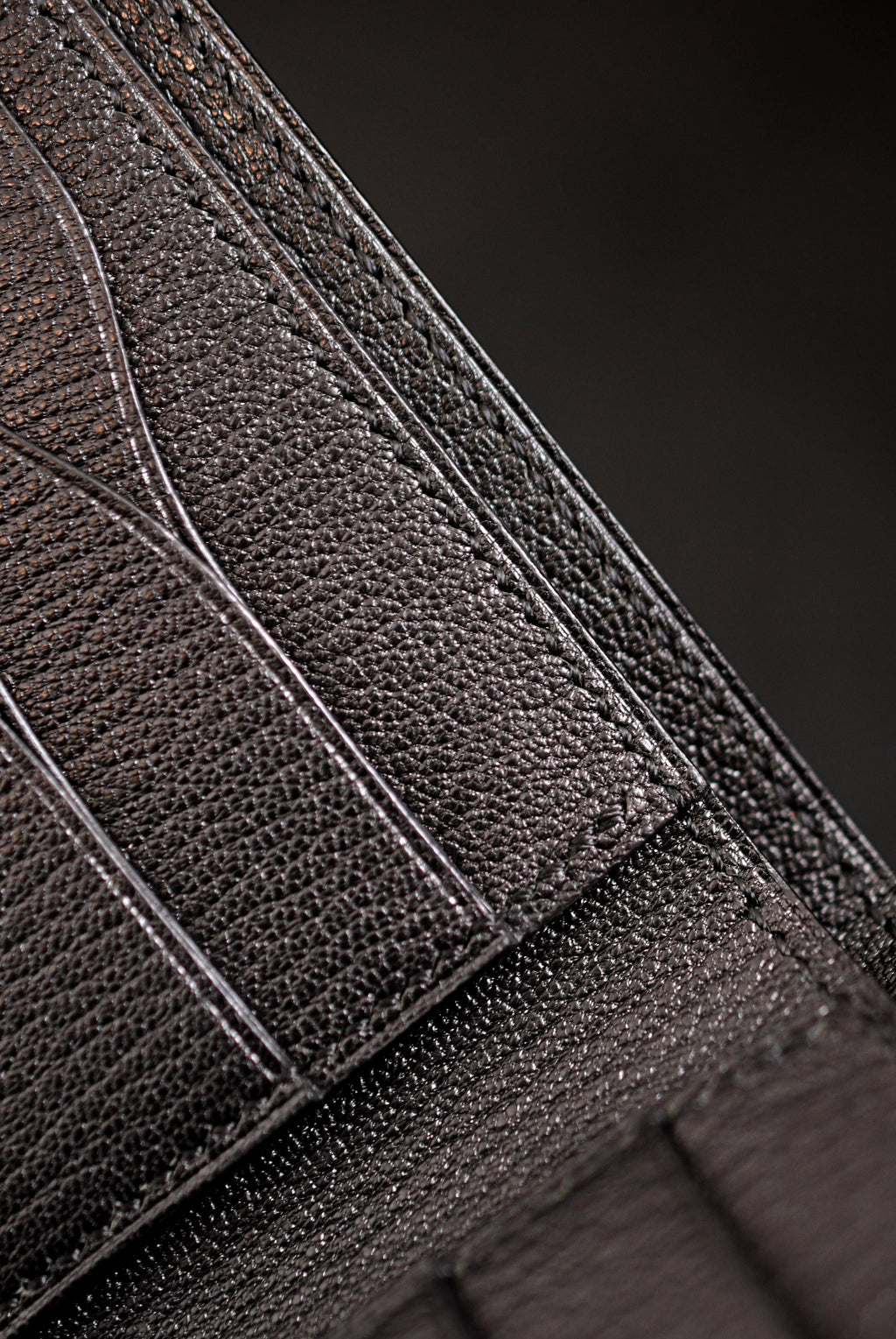 Inside of handmade black goat leather bifold wallet showing curved card pockets, heat-creased and hand-painted edges and saddle stitching — Jackson Boite