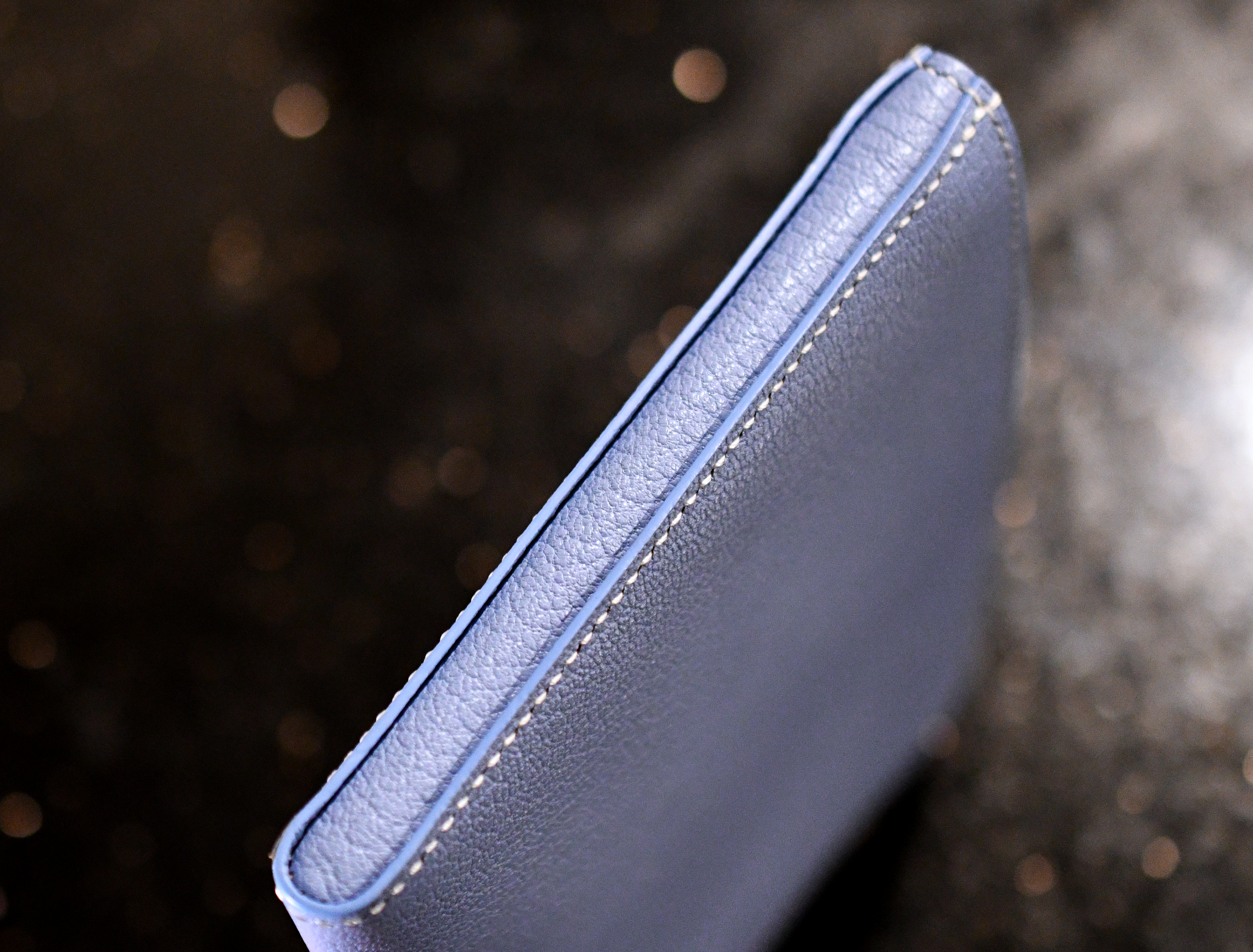 Side view of handmade leather small pouch showing soft leather edge, white saddle stitching and painted edges — Jackson Boite