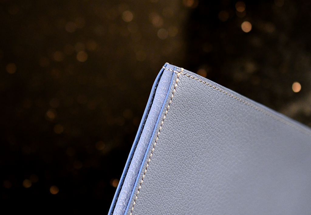Side view of handmade leather clutch in Alran Sully Bleu Vista with white saddle stitching and painted edges — Jackson Boite